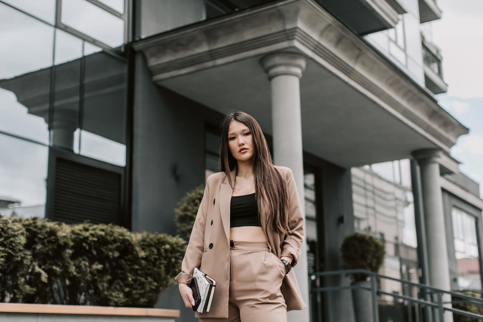 Silhouette bureau : ensemble tailleur beige, sac structuré et posture nette en extérieur
