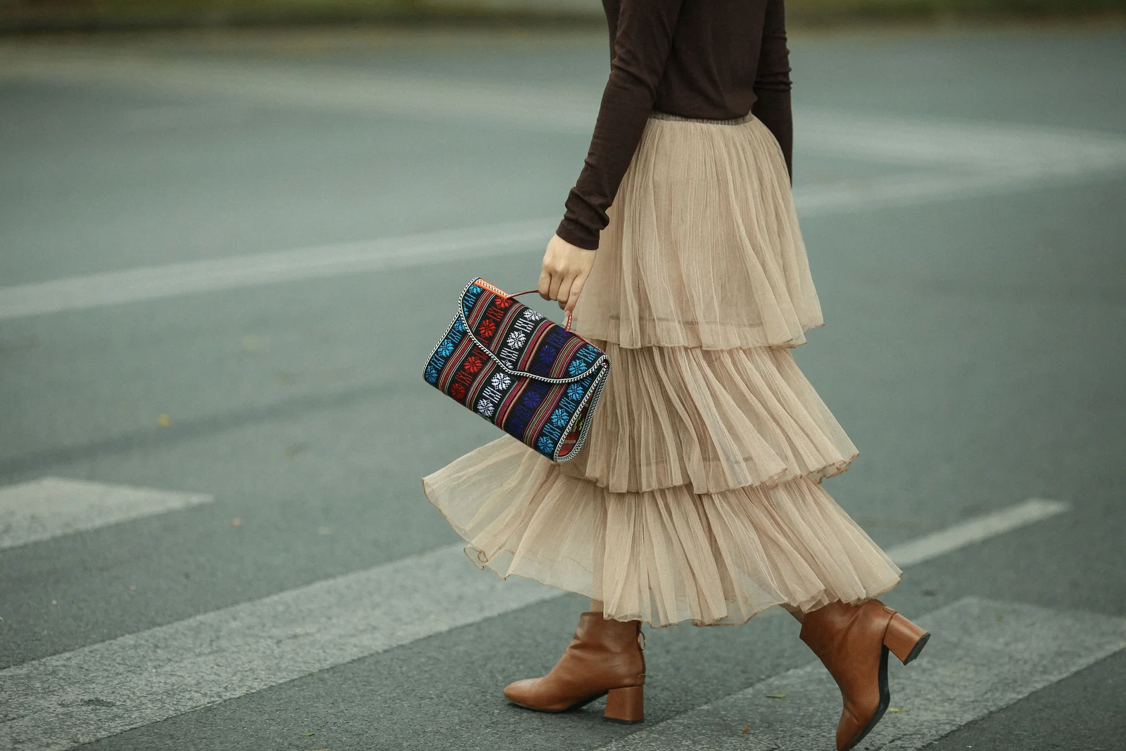 Jupe midi et bottines à petit talon portées en rue, silhouette allongée par la longueur mi-mollet