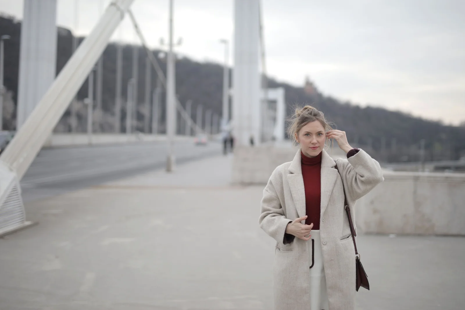 Manteau long clair porté sur un col fin rouge, seule pièce de couleur de la tenue, marche en ville par temps froid