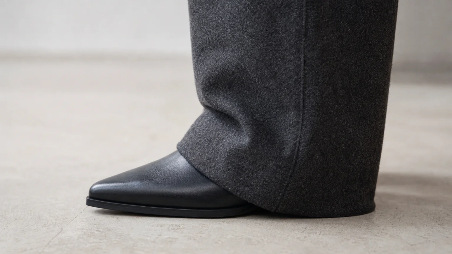 Ourlet de pantalon de tailleur formant une légère cassure sur une chaussure pointue