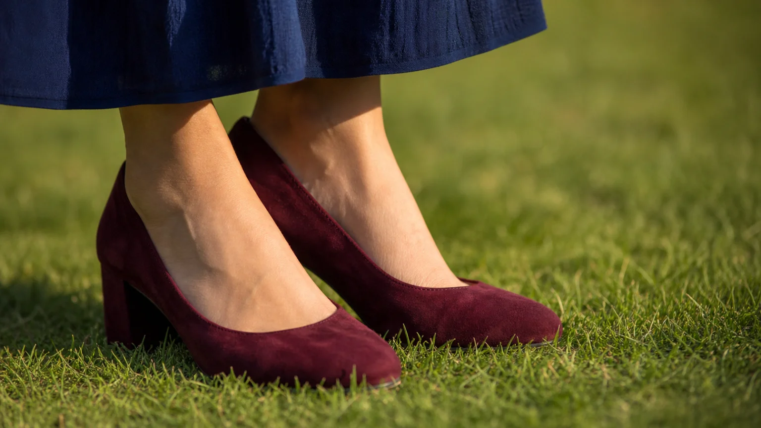 Chaussures à talon large bordeaux posées sur une pelouse lors d'un vin d'honneur
